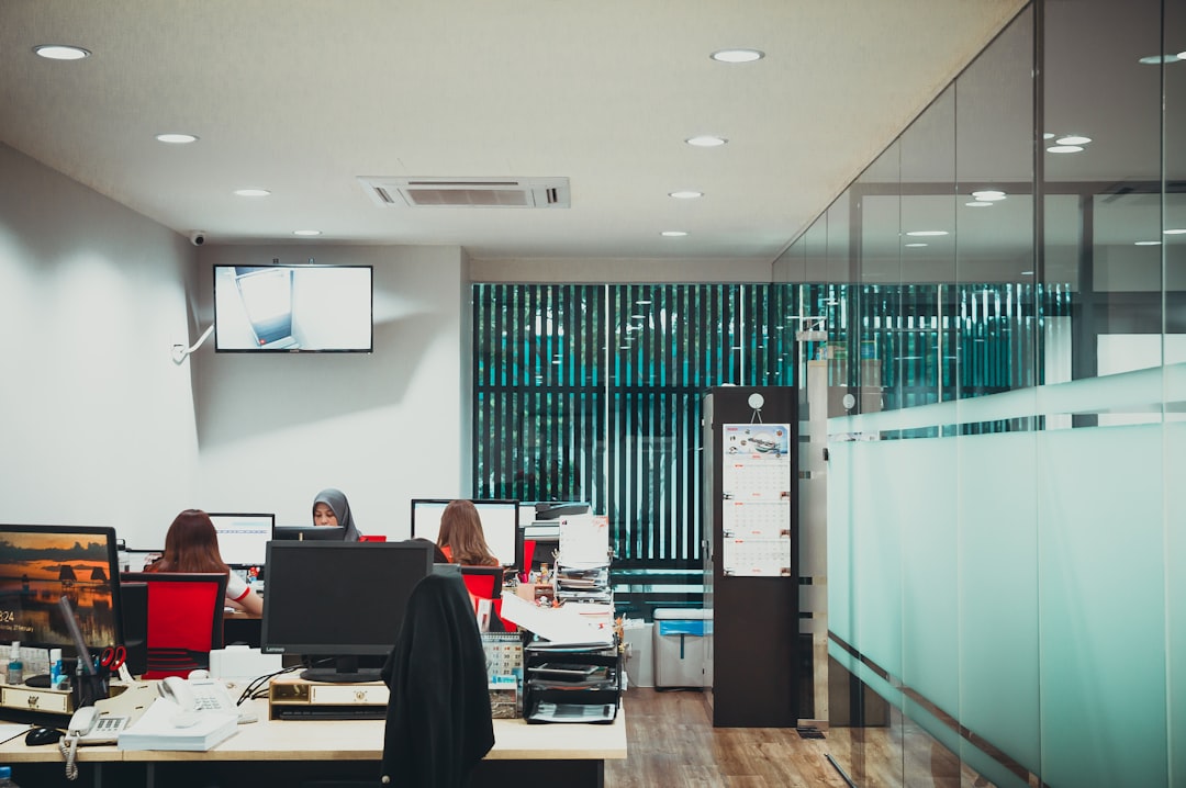 Moderno uredsko radno mjesto s računalima i radnim stolovima.